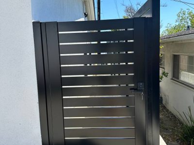 Modern black aluminum fence gate with horizontal slats. Fence Company Handy Maestro